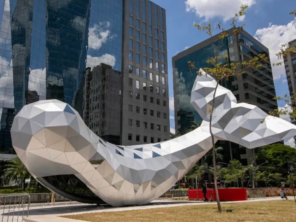 Escultura geométrica branca entre prédios de escritórios